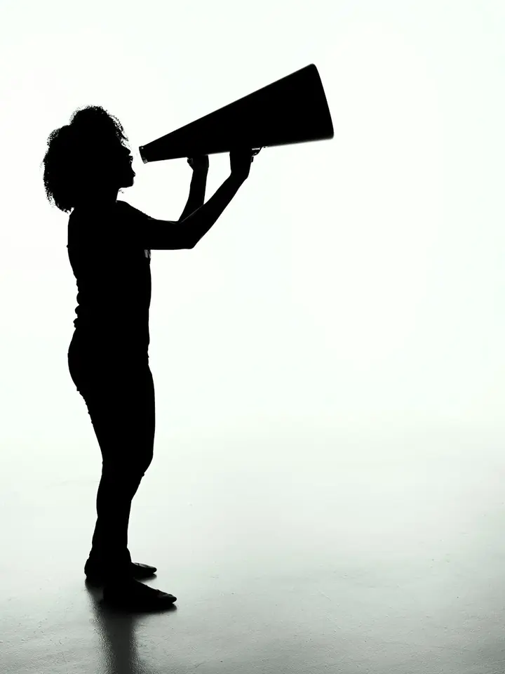 Silhueta de uma pessoa falando num megafone, contra um fundo branco.